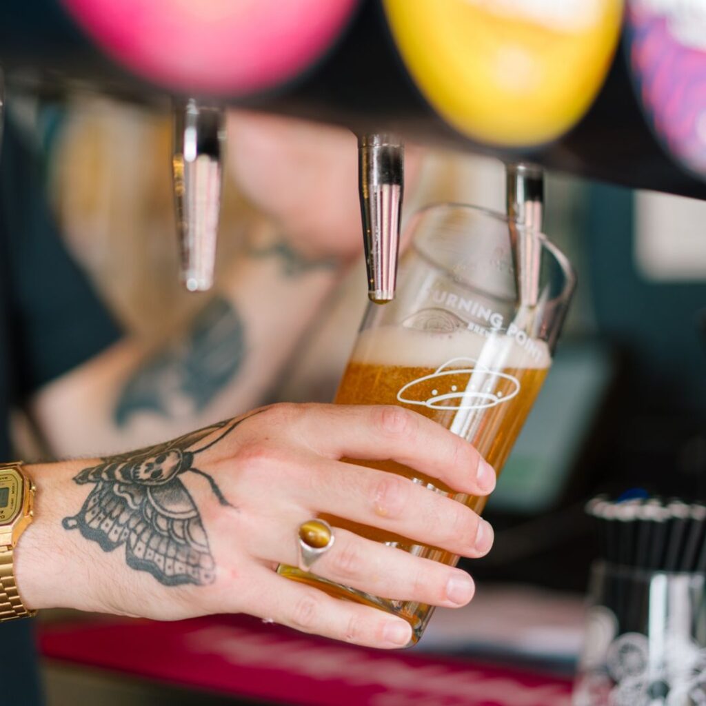 A photo of a staff member pouring a pint