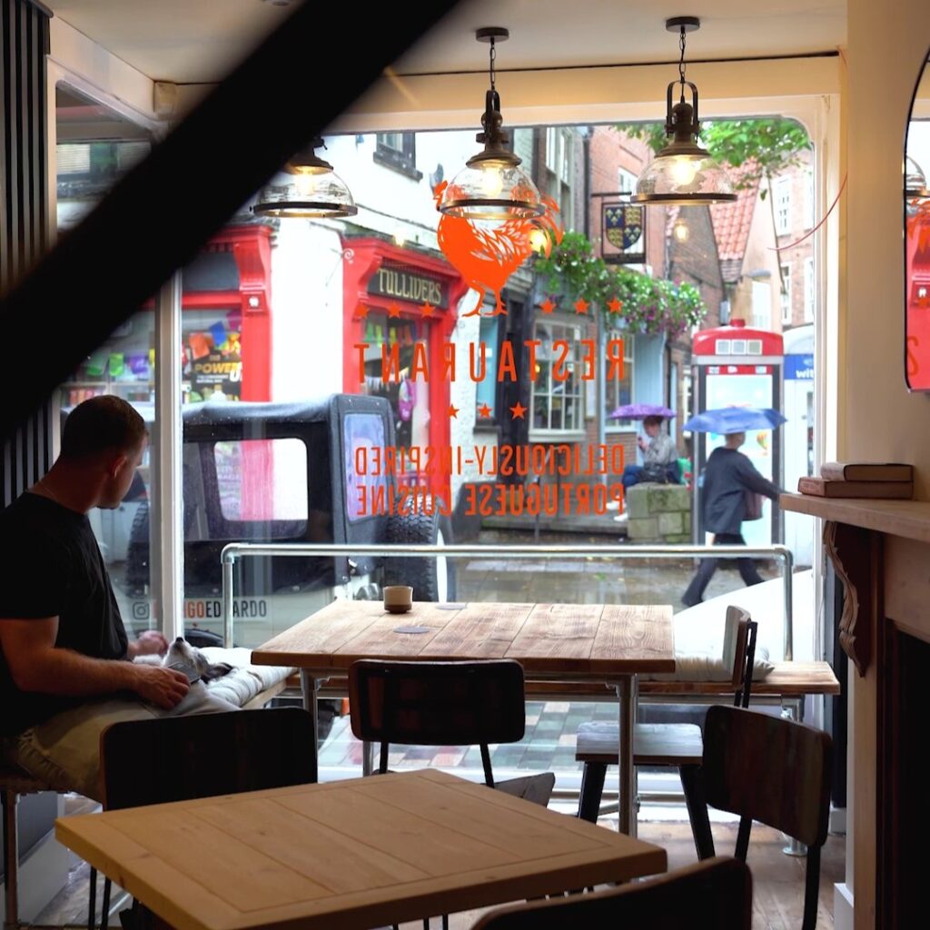 Interior of the Frango Eduardo restaurant with a man sat at a table