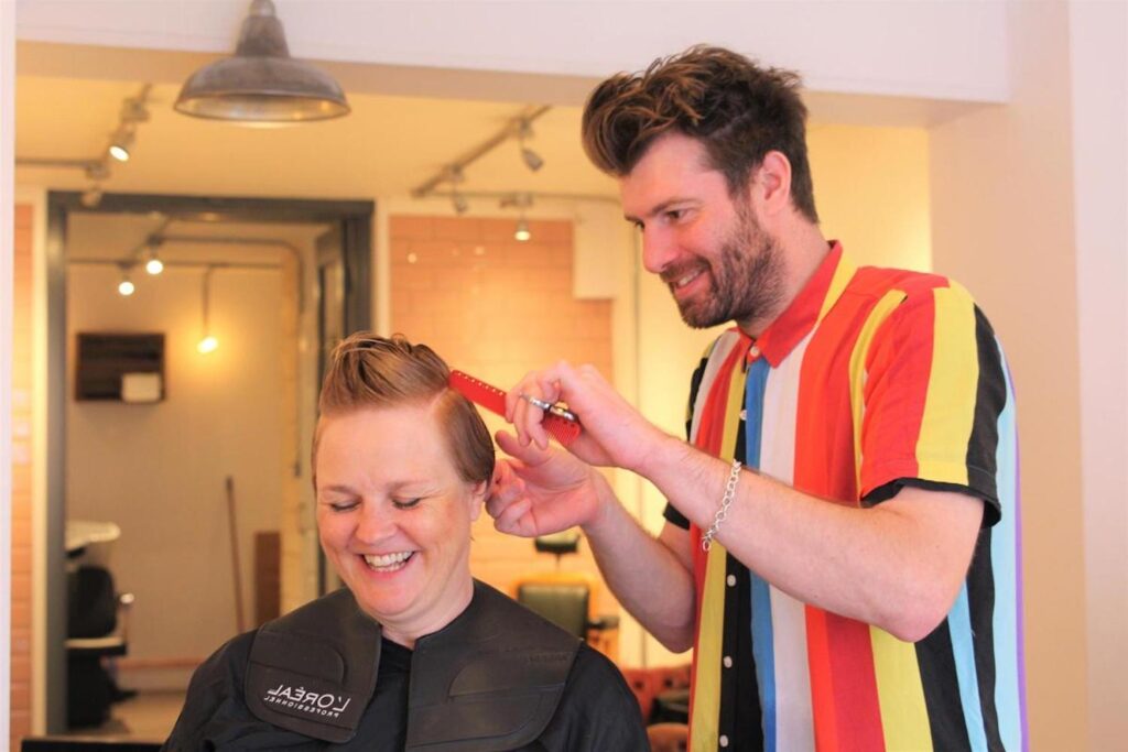 A man cutting a woman's hair