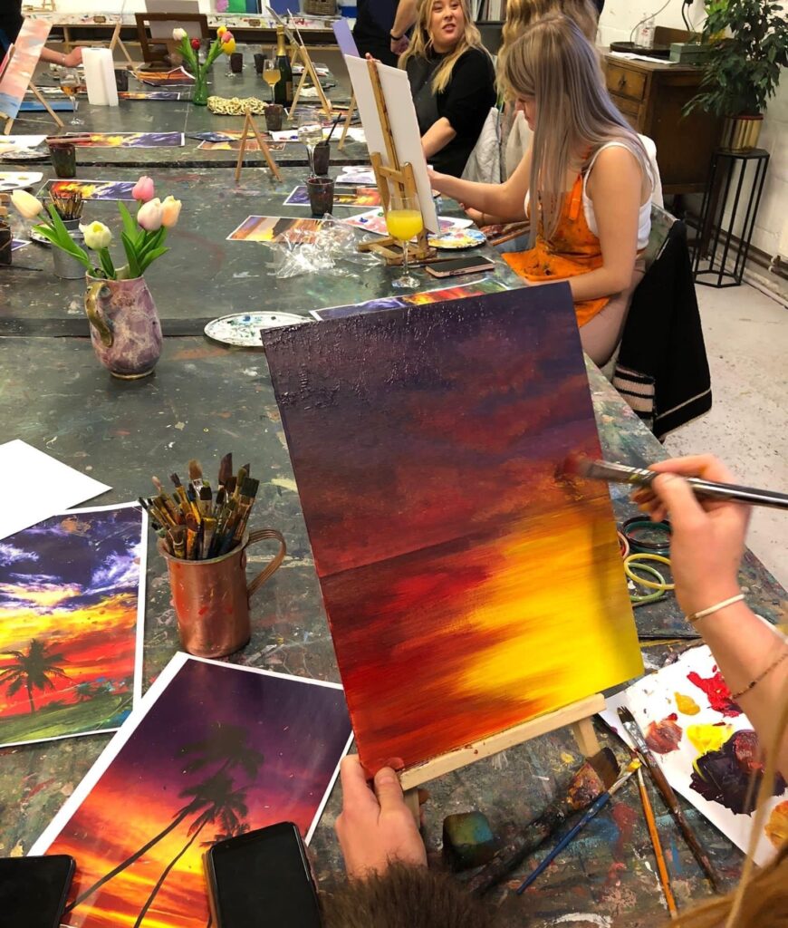A photo of a group painting a sunset