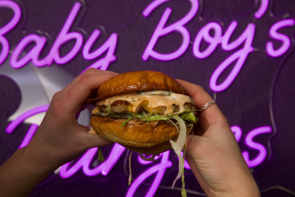 A photo of hands holding a burger