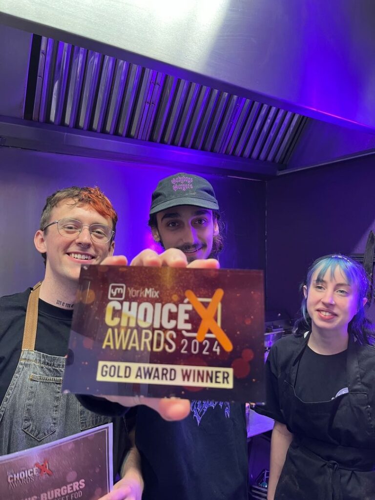 Two men and a woman holding a YorkMix Choice Awards Gold Award trophy