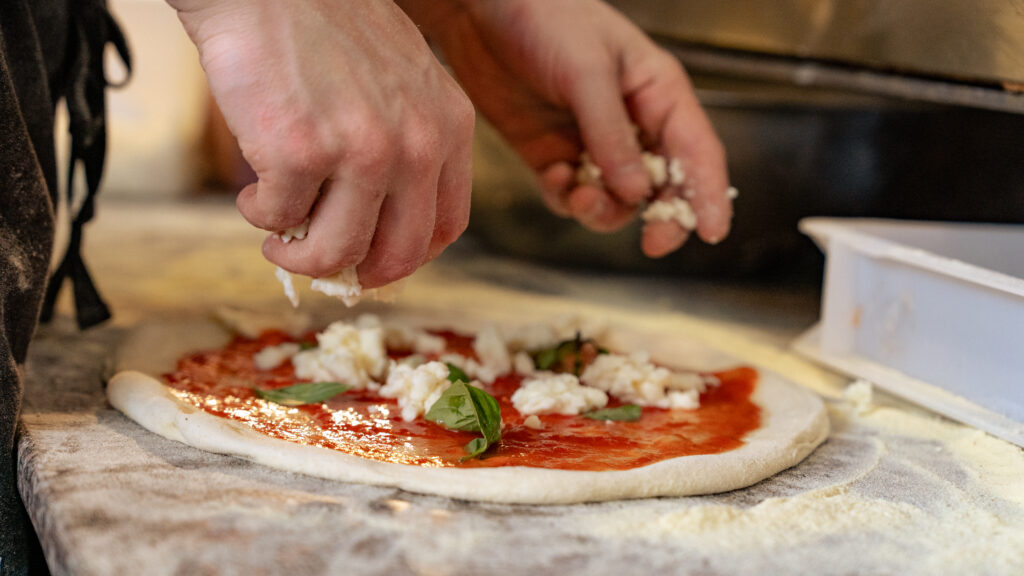 A photo of a person making a pizza